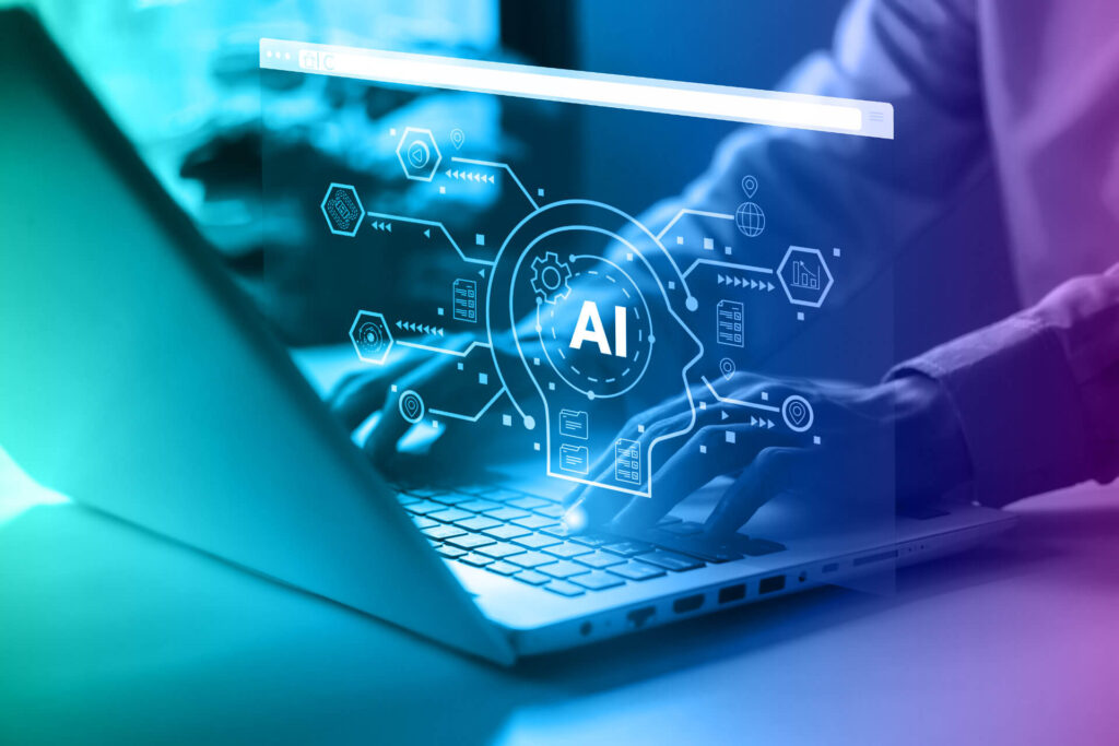 Eine Person, die an einem Schreibtisch sitzt und auf einem Laptop tippt. Über dem Laptop sind ein Kopf mit den Buchstaben "AI" dargestellt, von dem aus mehrere Stränge weggehen. Es soll KI-Tools darstellen.